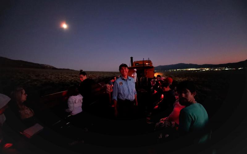 Astronomy intern Andrew Boyle and visitors in front of the Nevada Railway Star Train at night