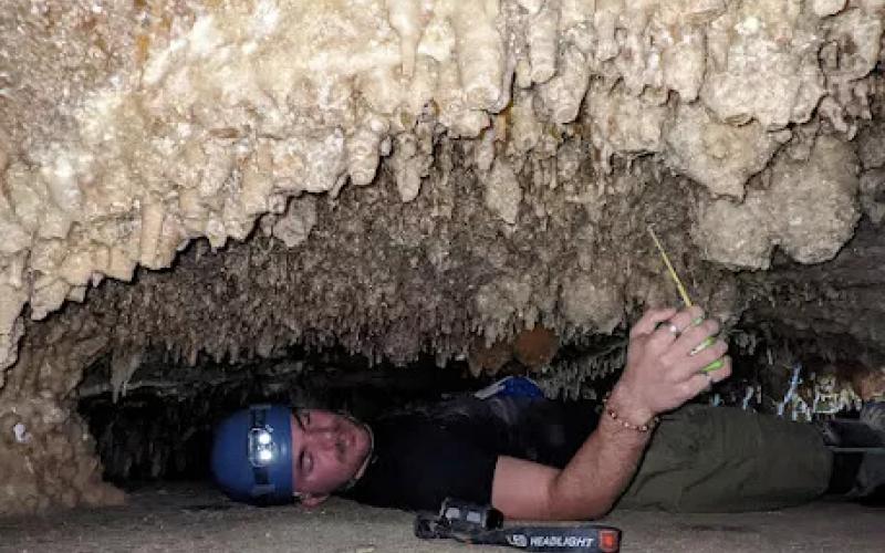 A volunteer measures turnip stalactites in a very small part of the cave.